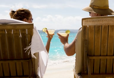 Two people clinking glasses on the beach