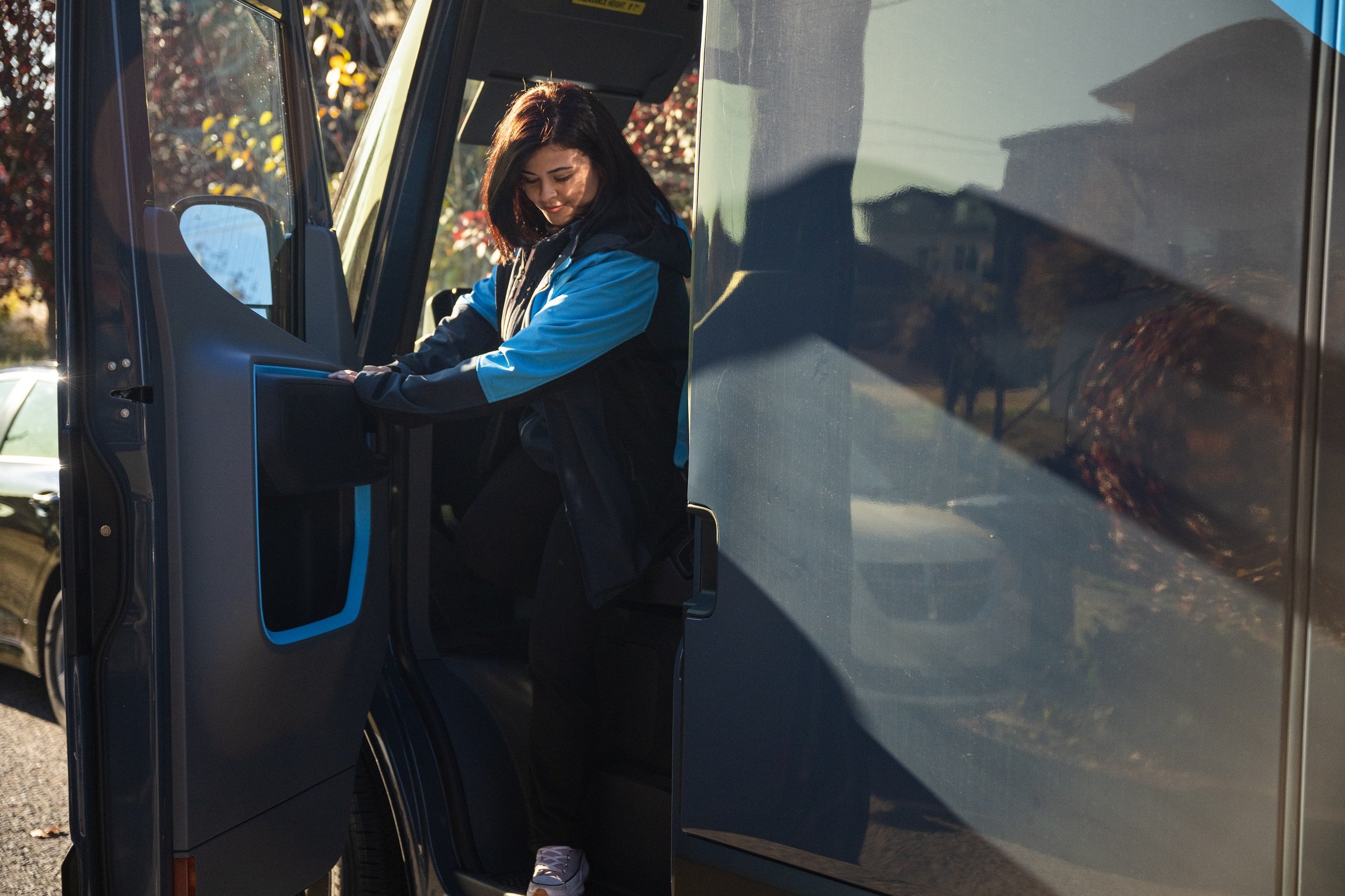 An Amazon driver exiting a delivery truck.