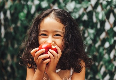 a girl eats an apple.