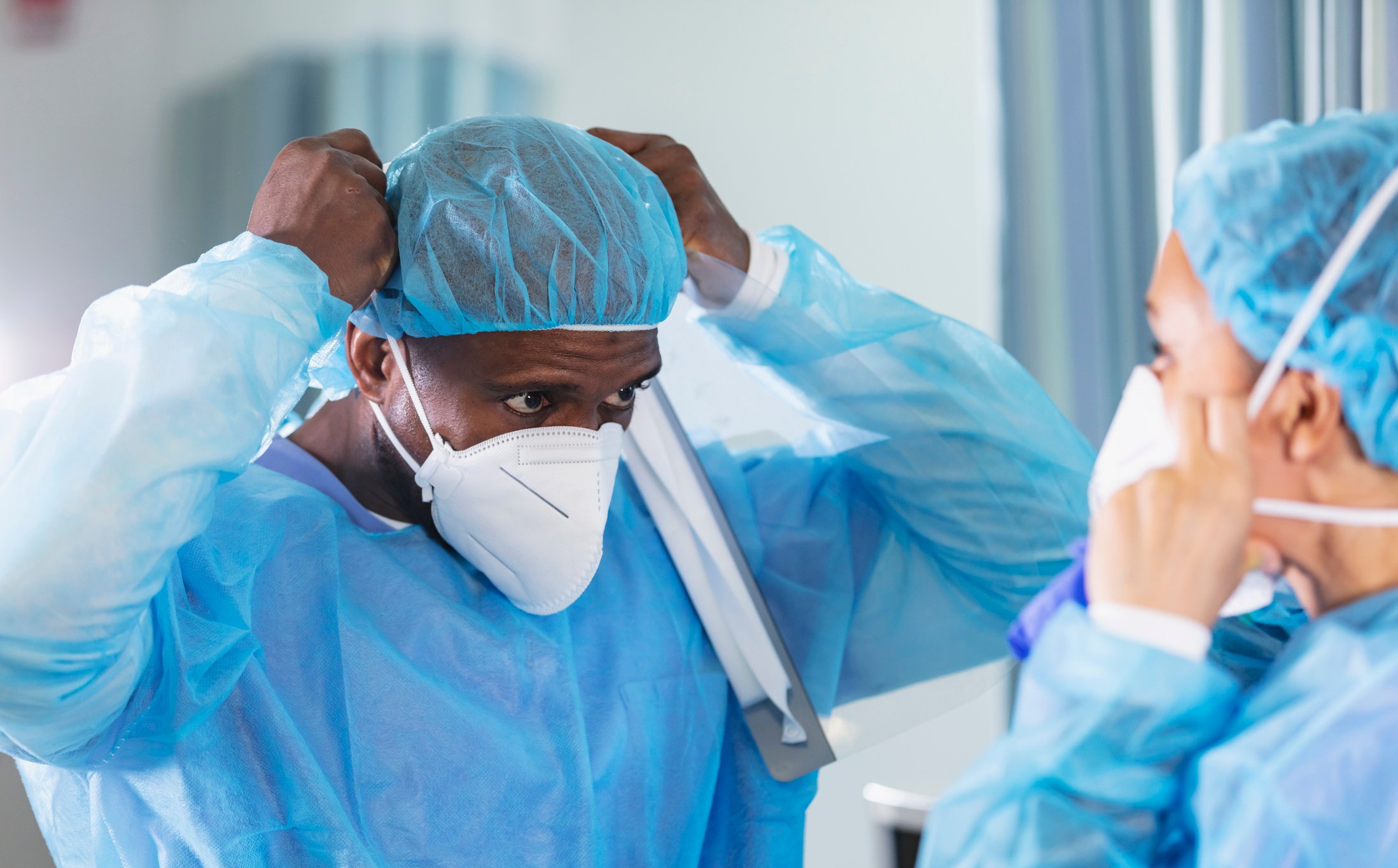 Healthcare workers put on N95 masks.