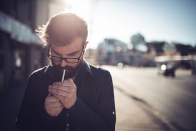 adult lights a cigarette