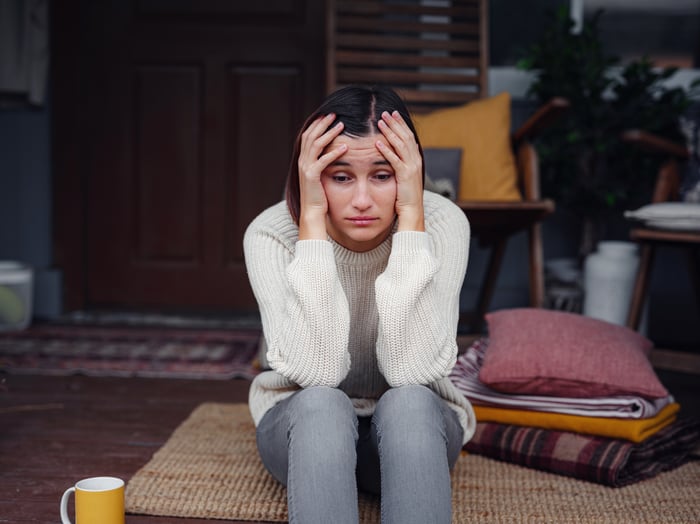 Person at home worried about student loan debt. 