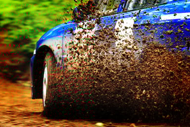 Car kicking up dirt as it accelerates