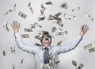 man with raised hands amid flying currency notes