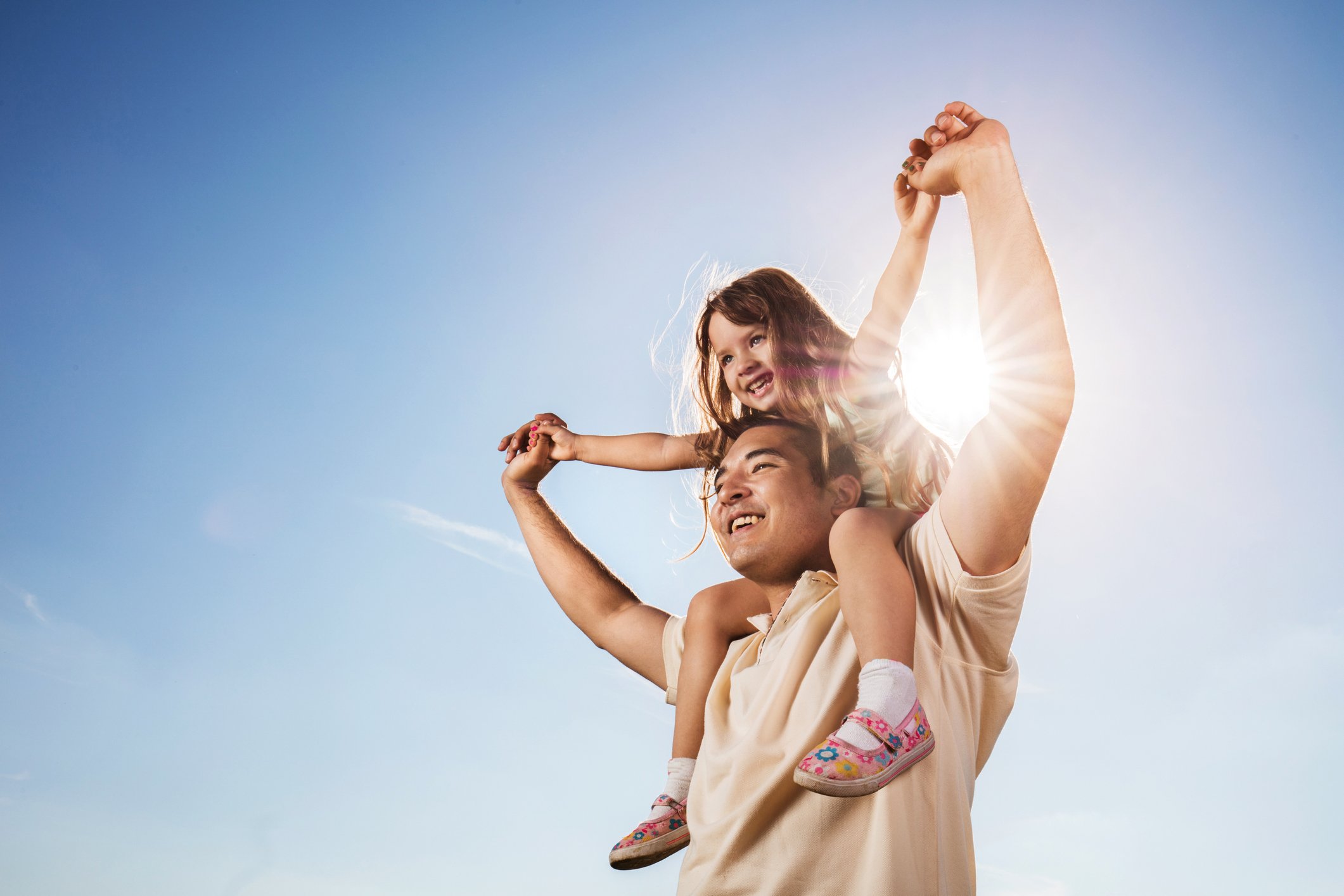 Adult and child gazing at sky during a sunny day