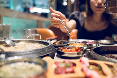 a diner prepares food at a Korean BBQ restaurant
