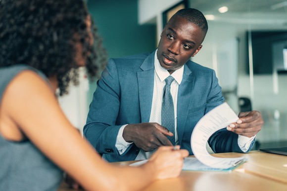 Two professionals have a discussion in an office setting.