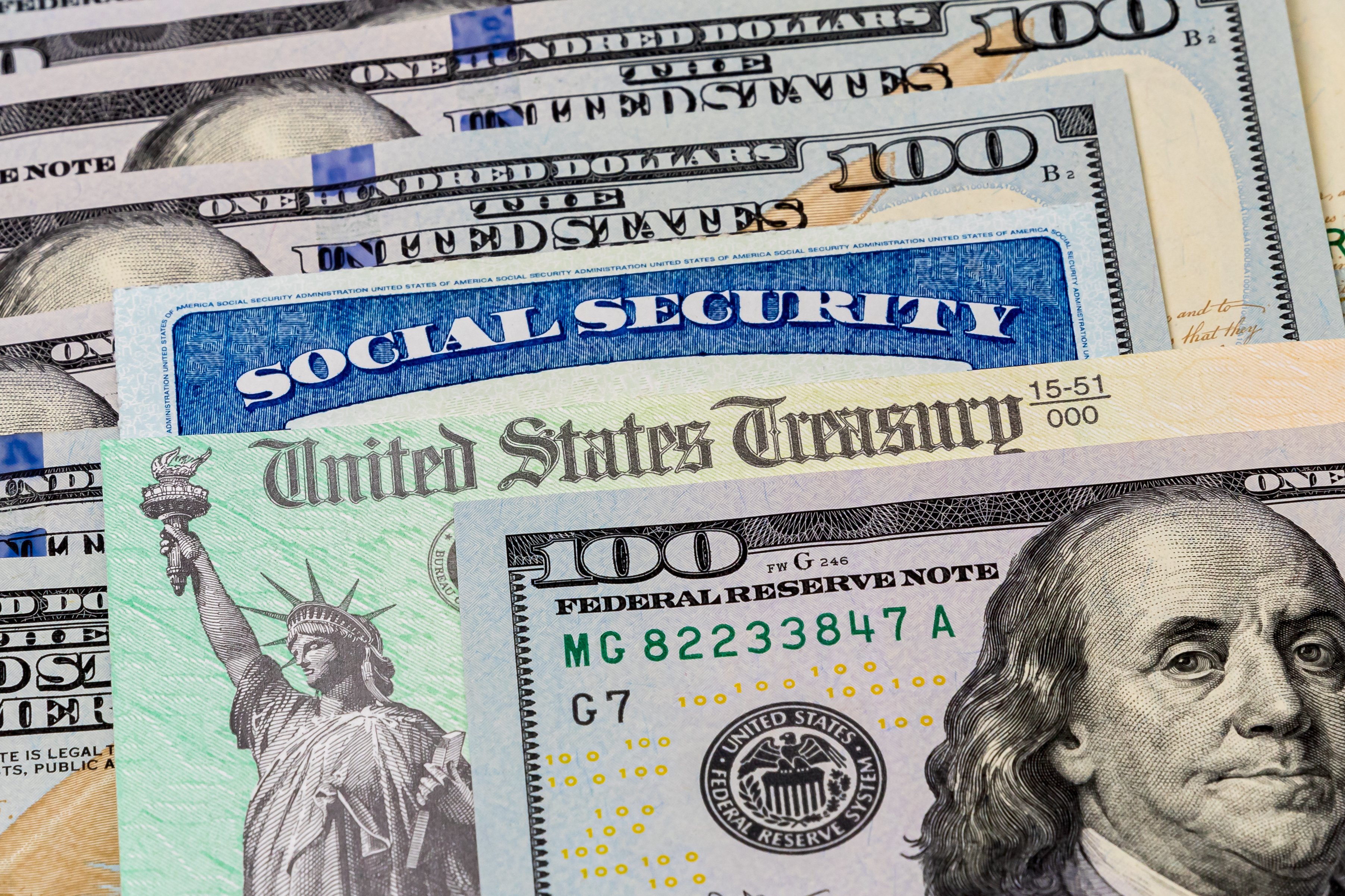 U.S. currency, a Social Security card, and a U.S. Treasury check lying on a table.