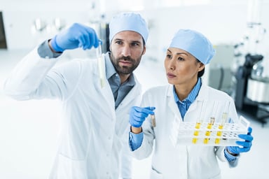 Two scientists reviewing a sample in a tube.