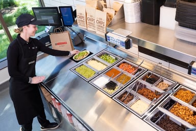 A Chipotle worker preps food at a test kitchen