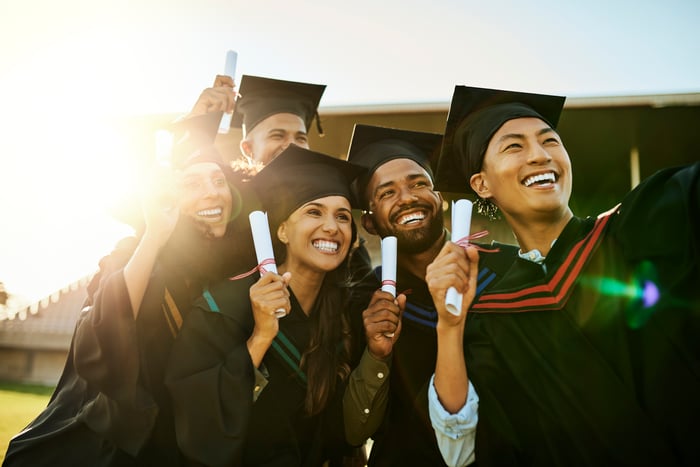 Group of college graduates holding diplomas. 