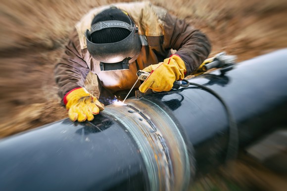 A close-up of a welder working on a pipeline.