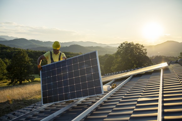 A person installing a solar panel.