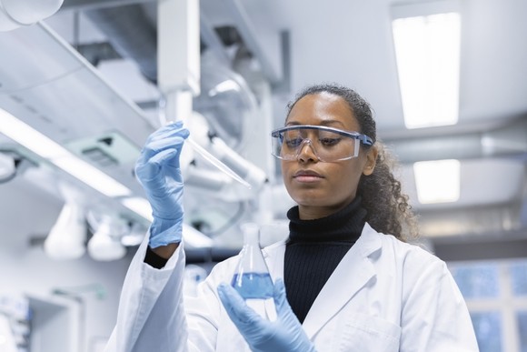 A person working with chemicals in a lab.