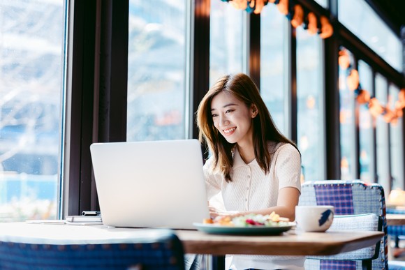 A person uses a laptop computer in a cafe.