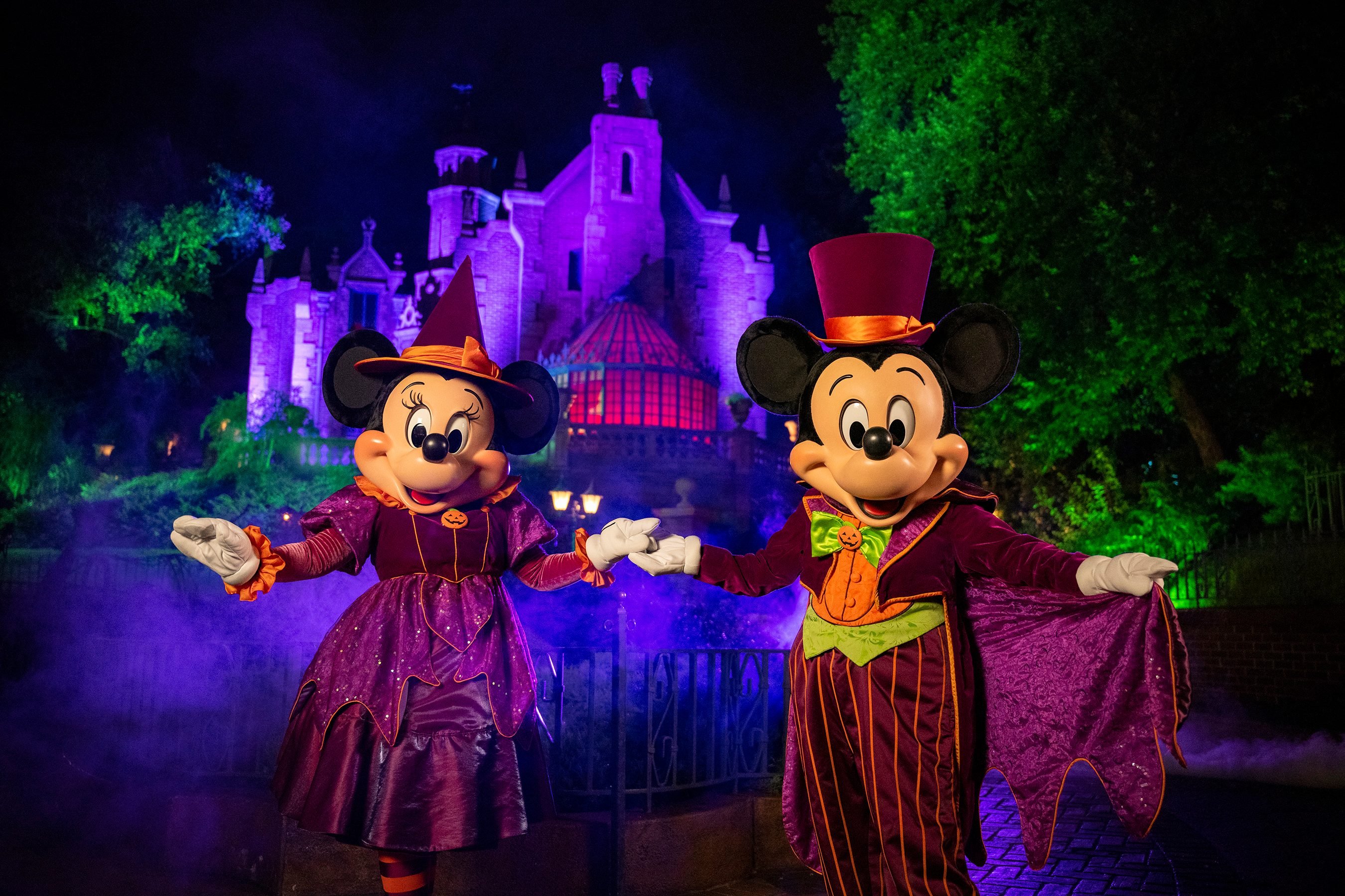 Minnie and Mickey wear Halloween outfits at Disney World.