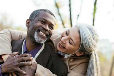 two older people hugging and smiling