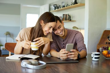 2 people laughing and looking at a computer
