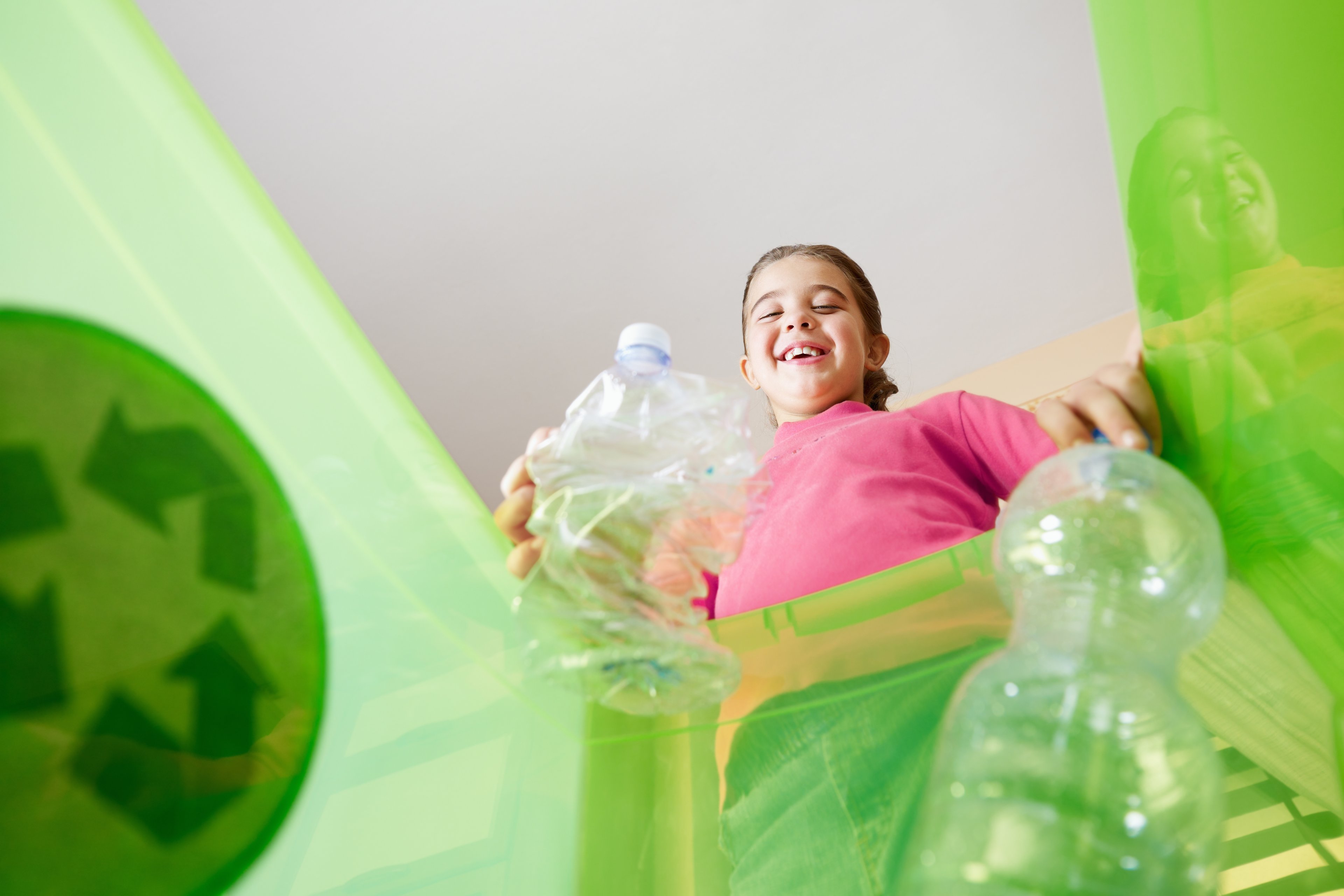 young girl recycling bottles