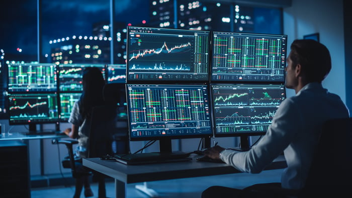 Man watching his stock performance on multiple monitors.