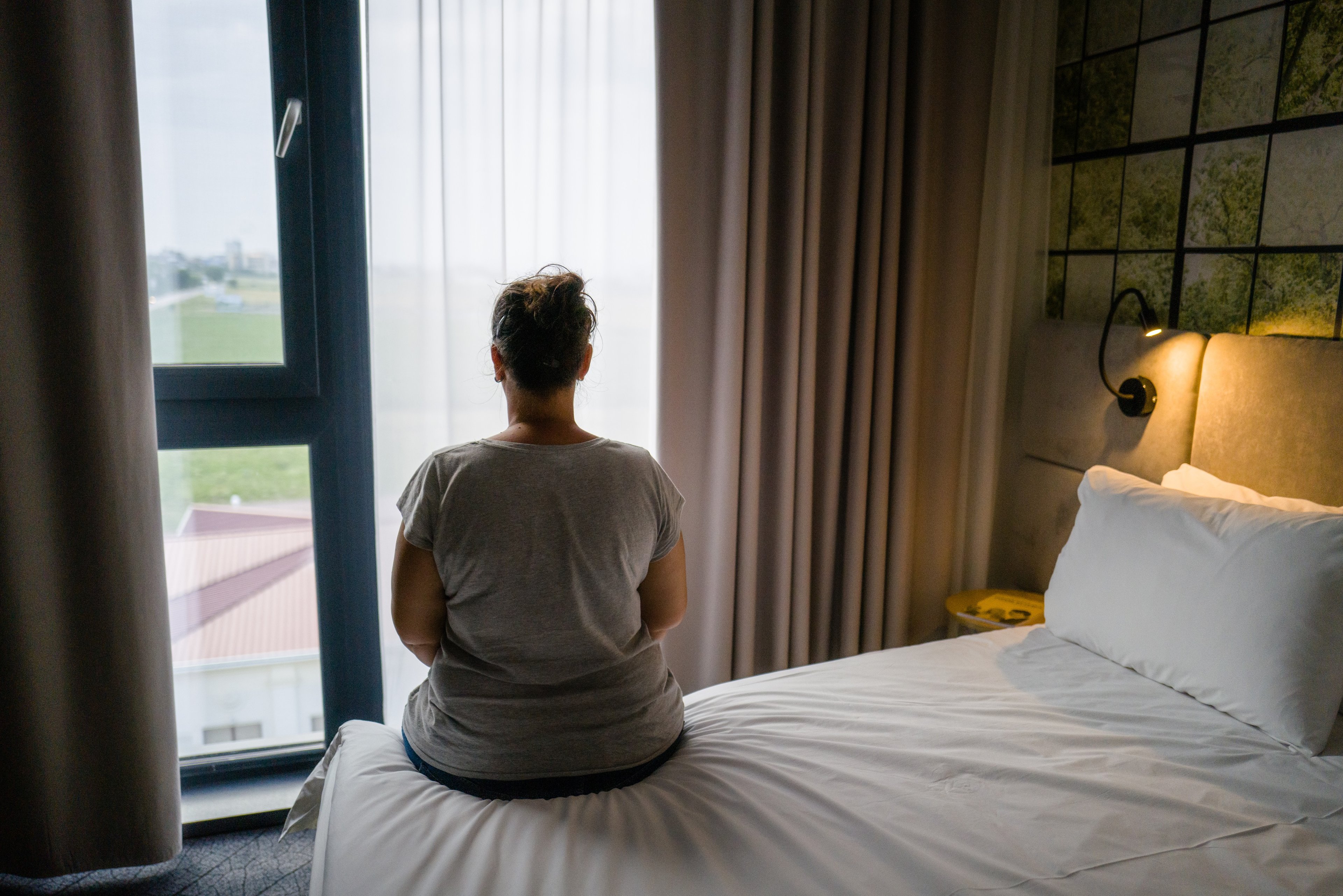 Woman on bed looking out window
