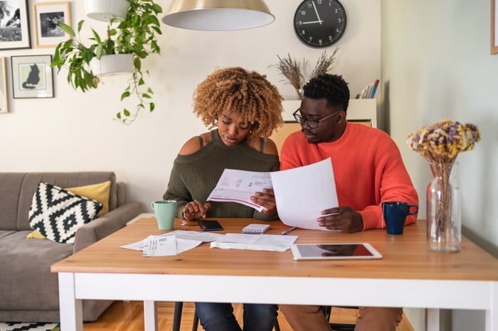 Couple looking at papers and using calculator.