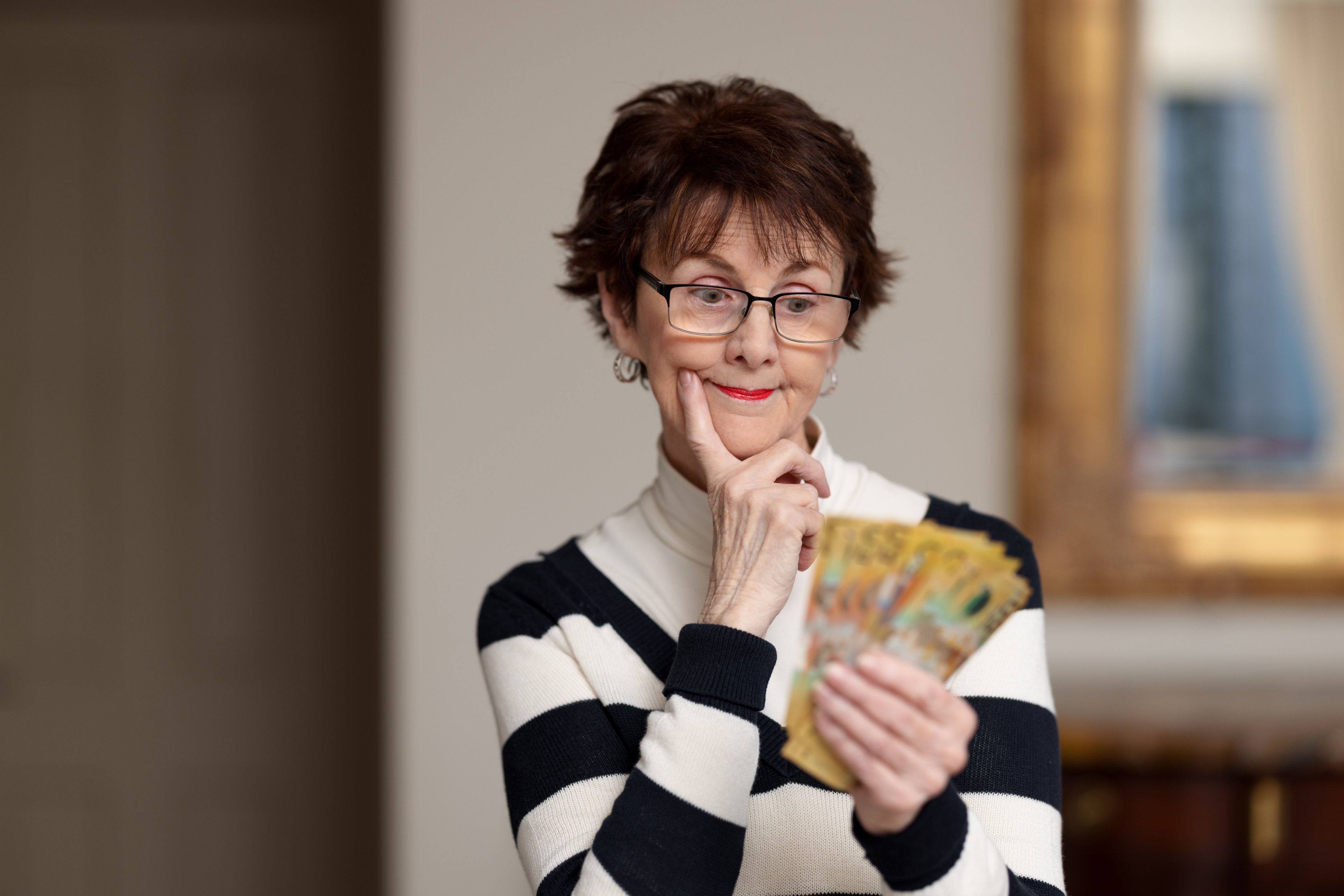 Elderly person pondering their finances.