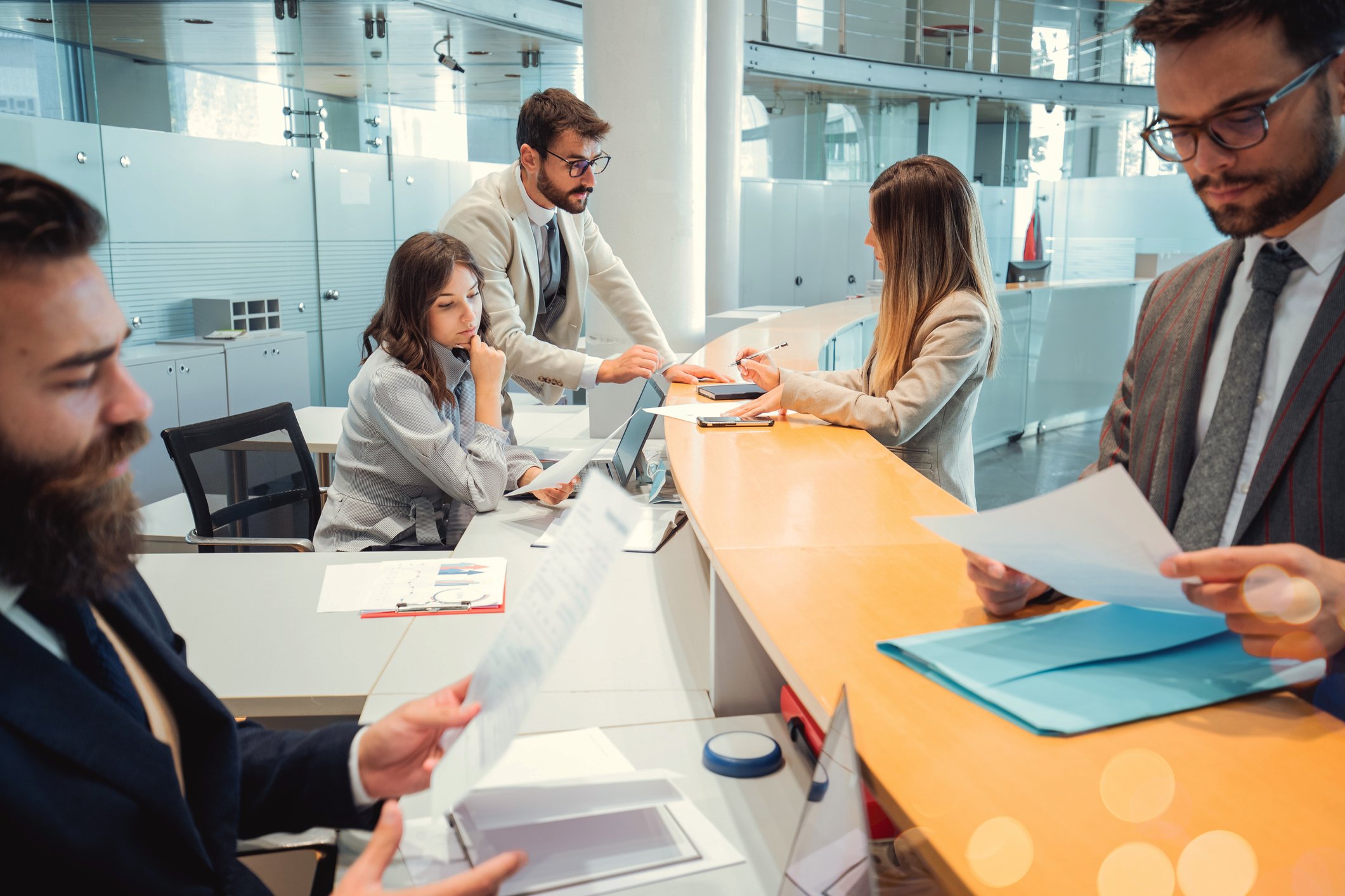 multiple bank tellers help customers