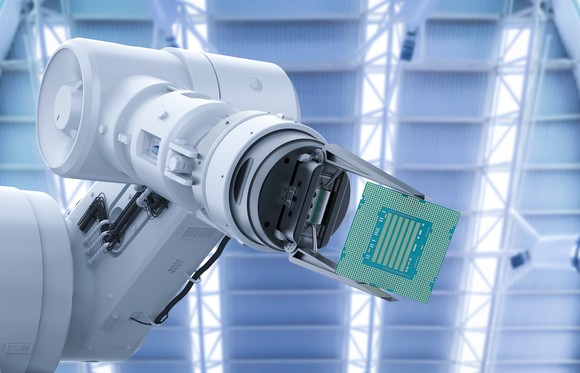 A robot arm handling a computer chip.