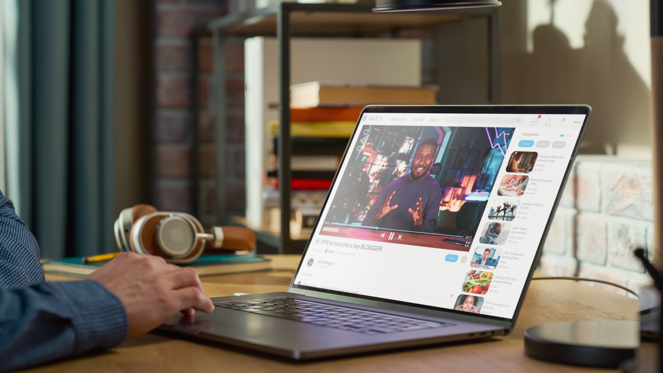 Person at a desk watching a video on laptop