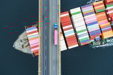 cargo ship under bridge with truck supply chain