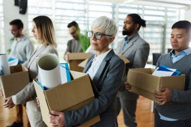 Fired employees carrying belongings in boxes