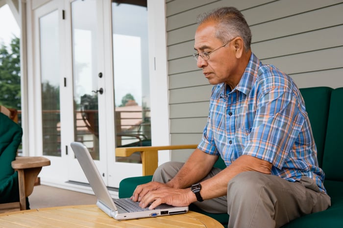 A person using a laptop outdoors.