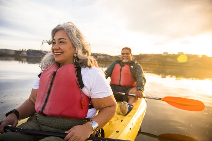 A couple share a kayak on a lake.