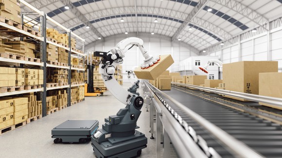 An image inside a warehouse where a robotic arm moves packages.