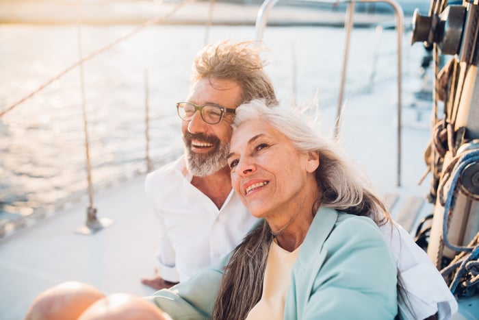 Two people sitting on a boat and smiling.