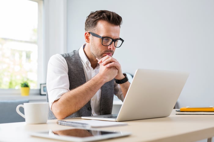 A person with a serious expression at a laptop.