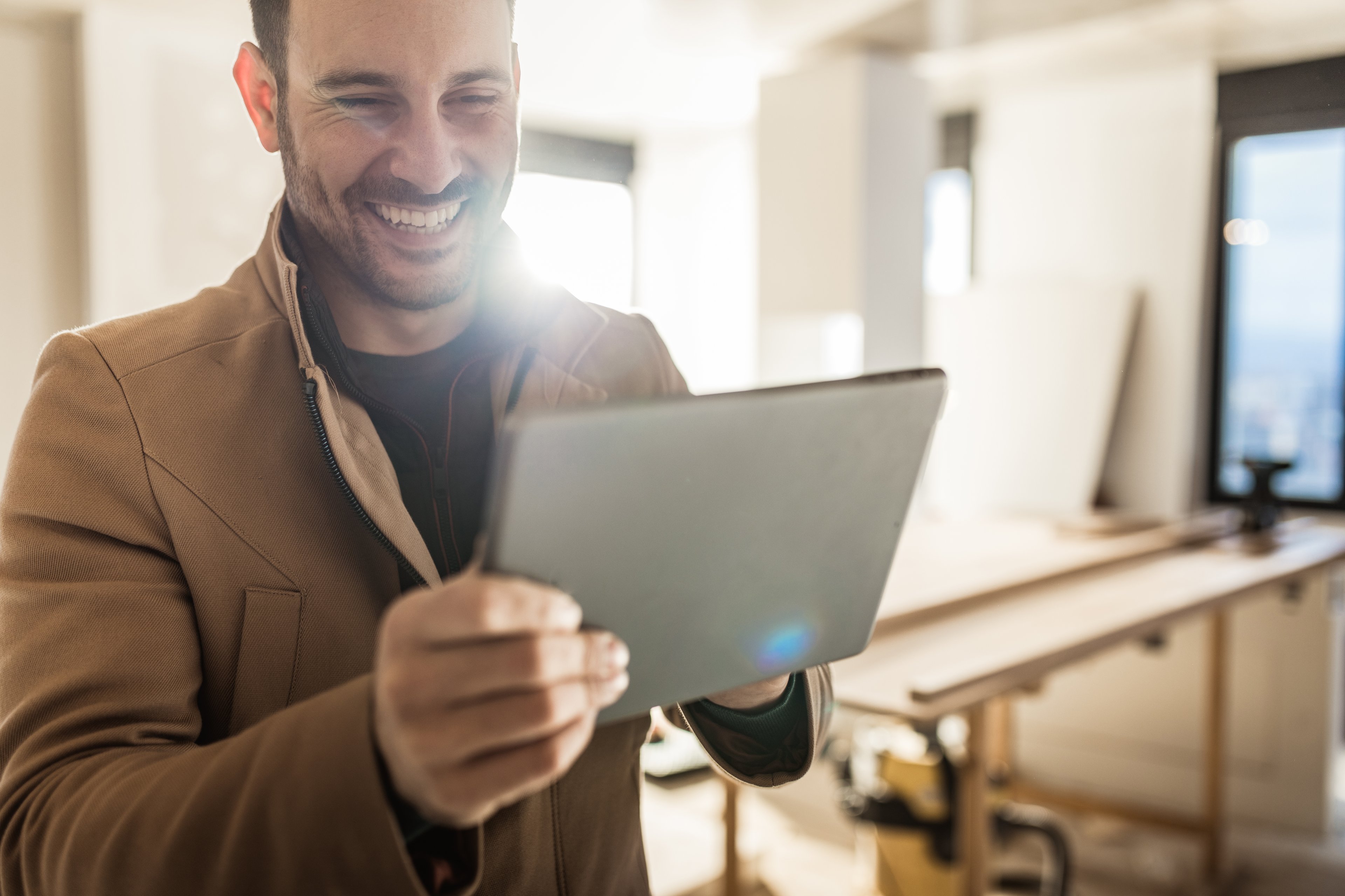 A happy investor looks at a tablet.