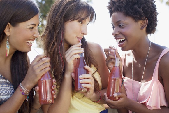 Three friends enjoying beverages. None of them are smoking.