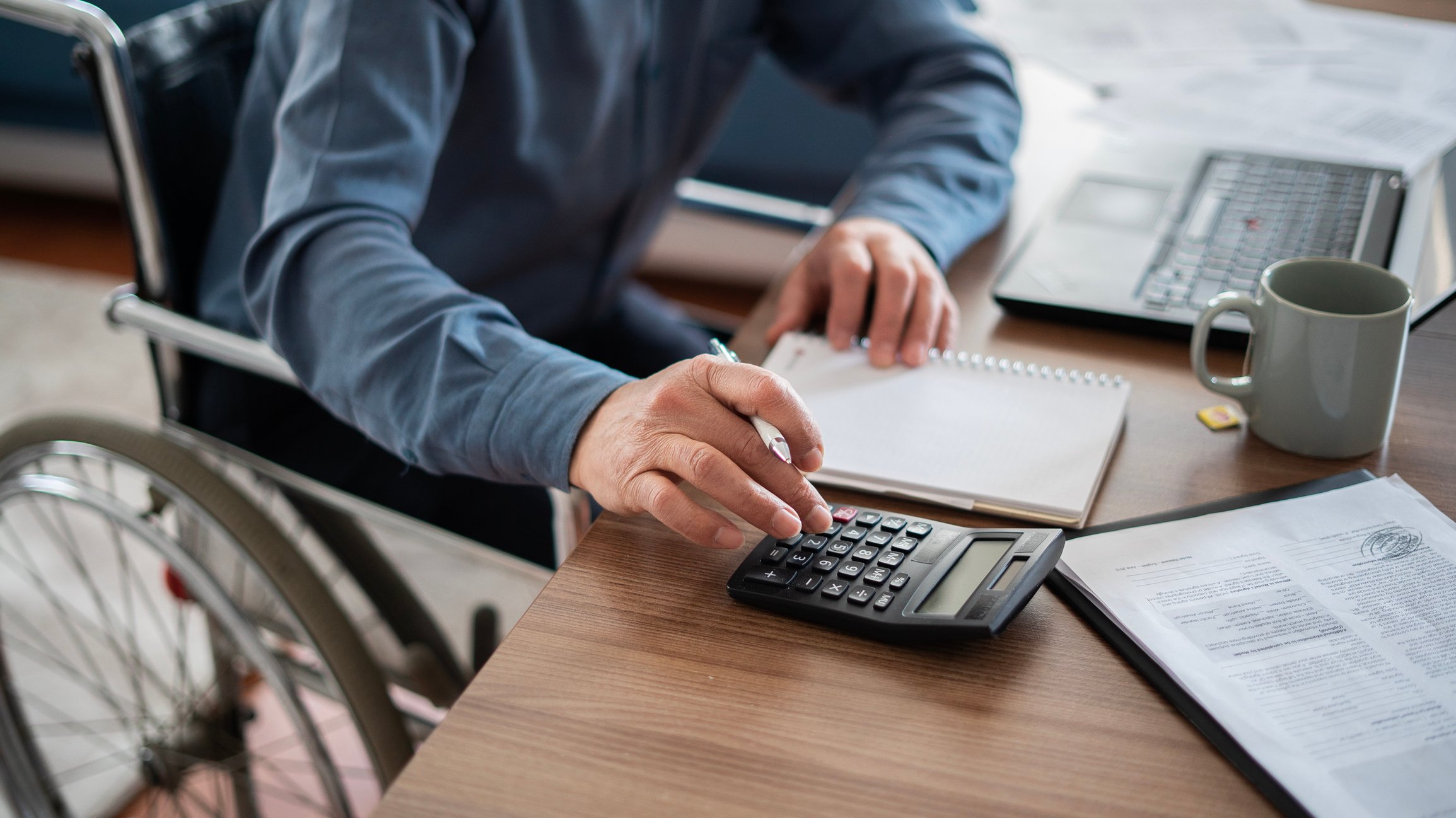 man in wheelchair, calculating investments