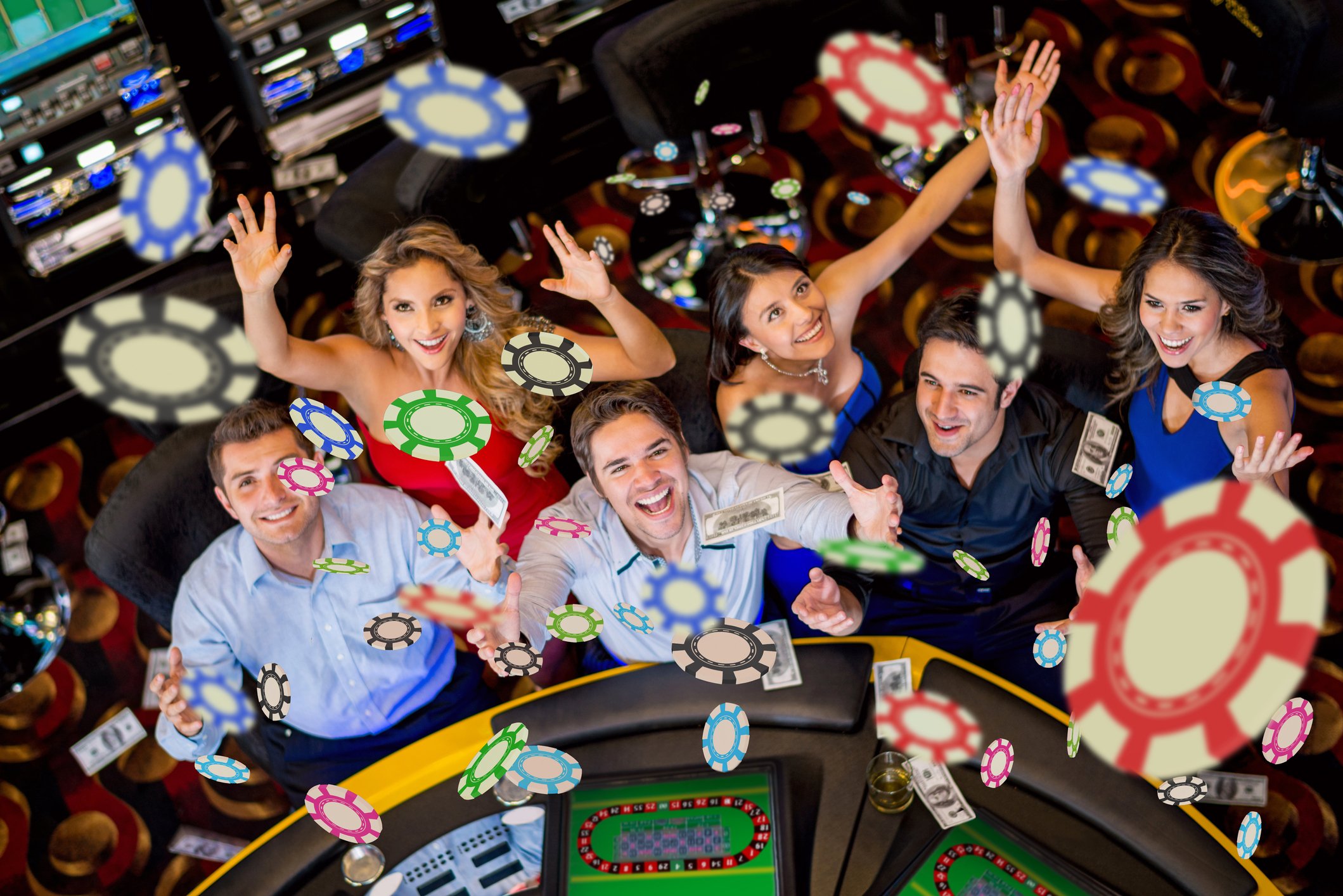 Friends at a casino table throwing their chips in the air. 