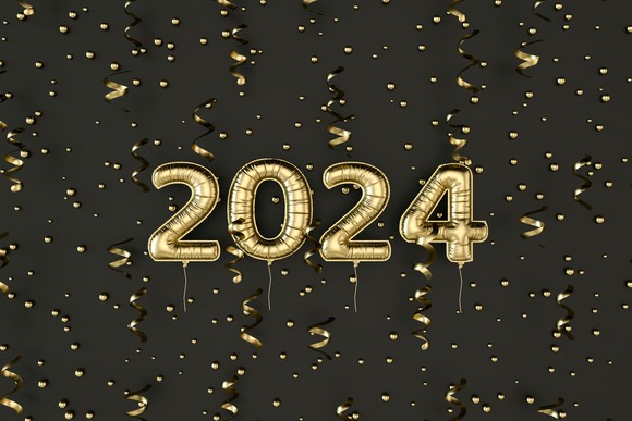 Gold balloons in the form of 2024 are set against a black and gold background.