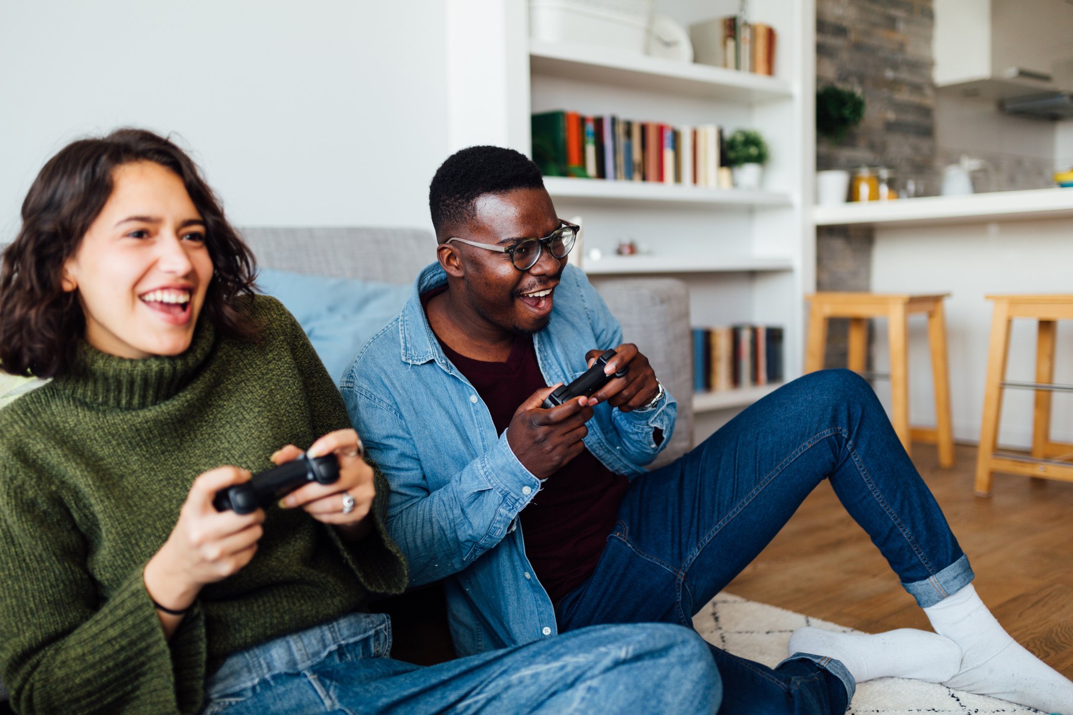 two people play video games on a couch