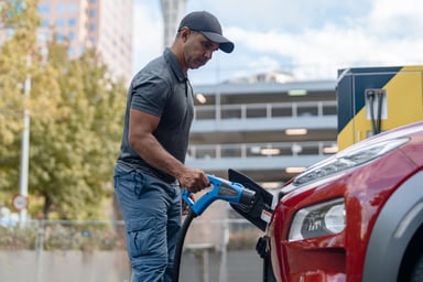 A driver charges an electric vehicle. (1)