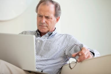 Serious Senior Using Laptop Social Security Getty