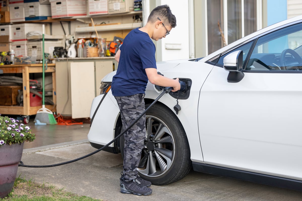 A boy charges an electric car.