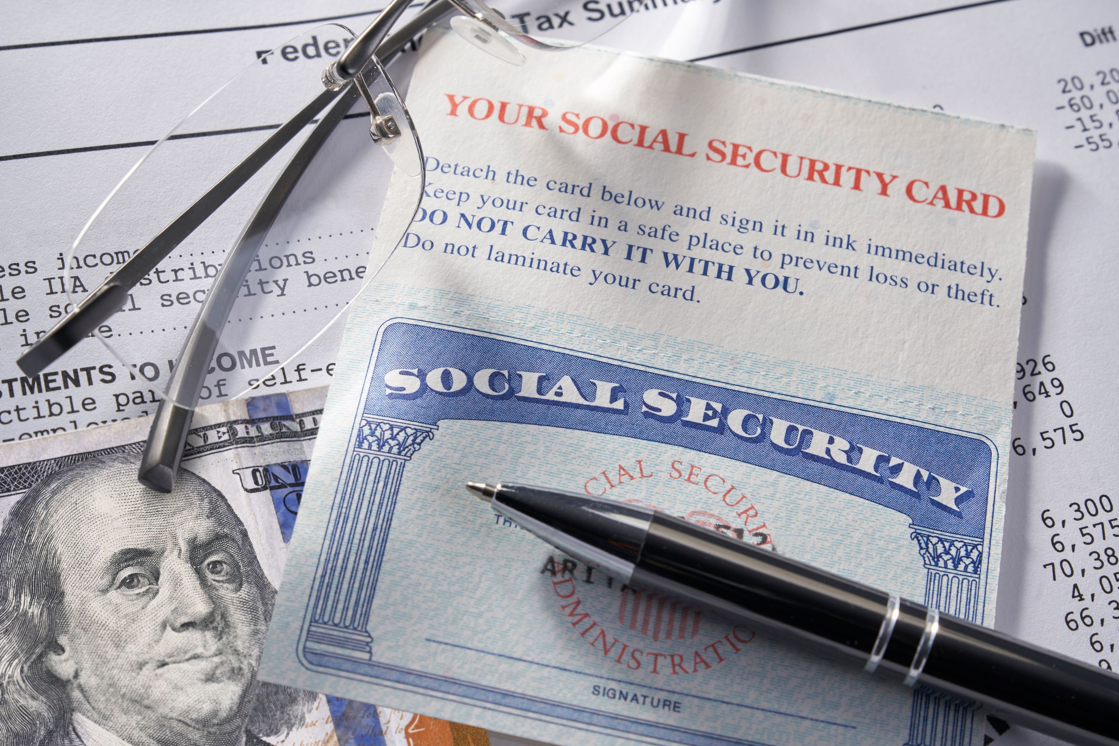 A Social Security card, Ben Franklin, and a pen.