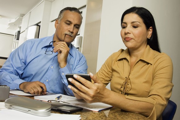 Two people looking at a calculator.