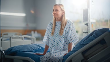 Patient sitting on hospital bed.