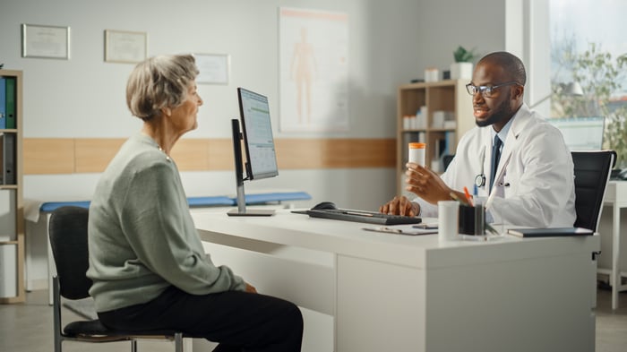 A medical professional consults with a person seeking information. 